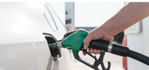 hand filling white car with diesel at pump